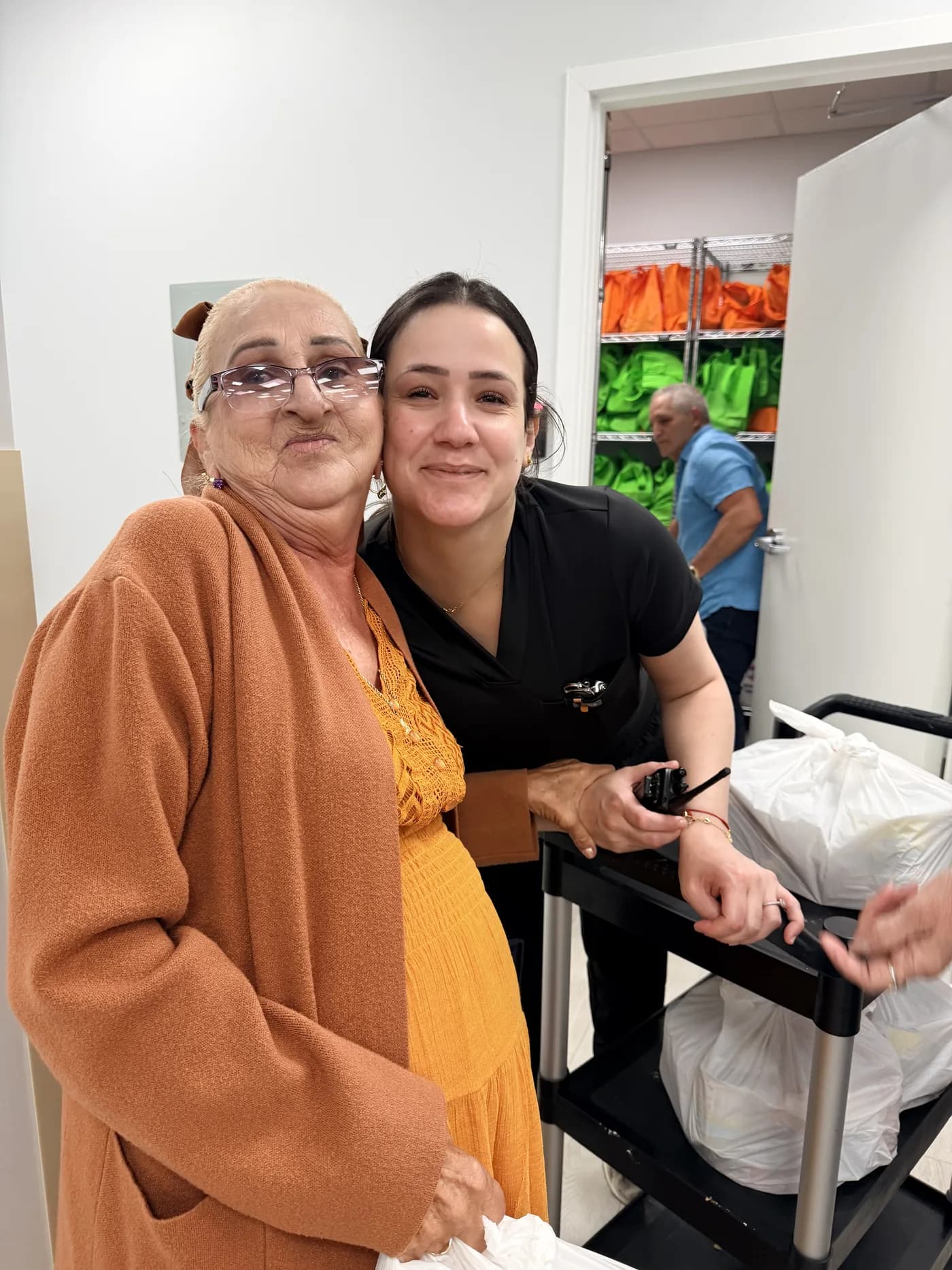 Volunteer embracing a neighbor after handing her a bag of groceries at a Giving Future Foundation distribution