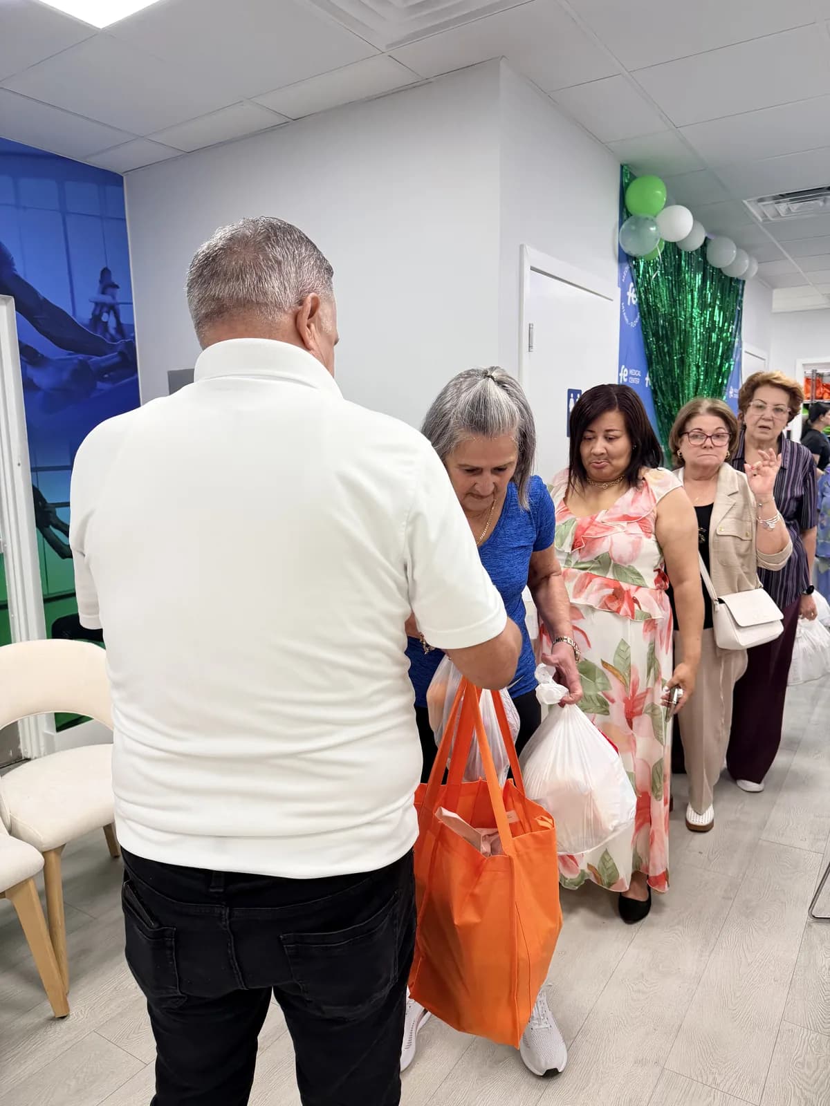 Volunteers lining up bags of groceries for community distribution